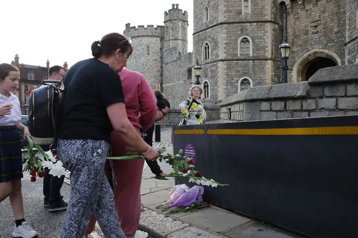 Хора поднасят цветя пред замъка Уиндзор в памет на Елизабет II