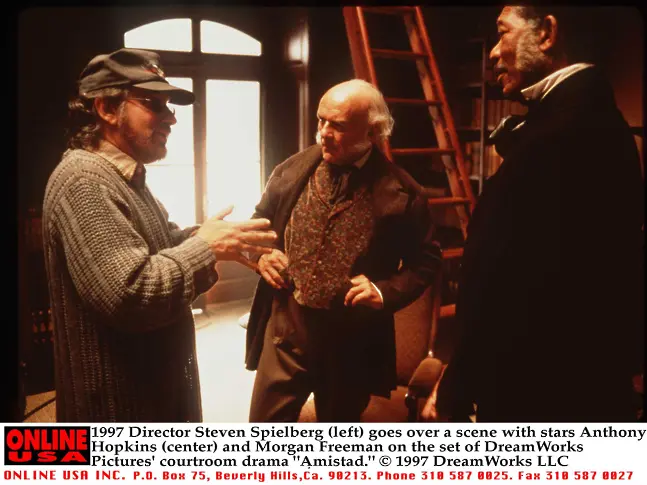 1997 г. Режисьорът Стивън Спилбърг разглежда сцена със звездите Антъни Хопкинс и Морган Фрийман на снимачната площадка на съдебната драма "Amistad".