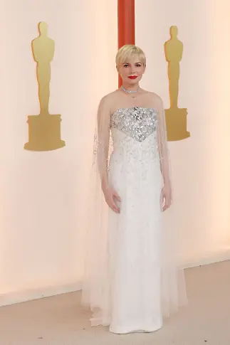 Мишел Уилямс, номинирана за най-добра актриса, носеше искрящо бяла рокля на Chanel Couture и чорапогащник с диамантени нишки на Tiffany & Co